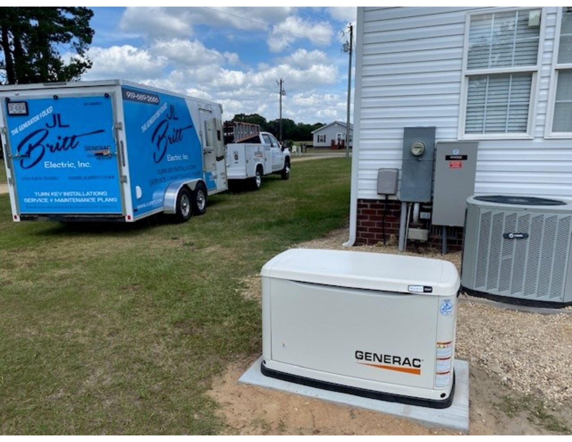 JL Britt Electric service trucks and a freshly installed Generac generator beside a home